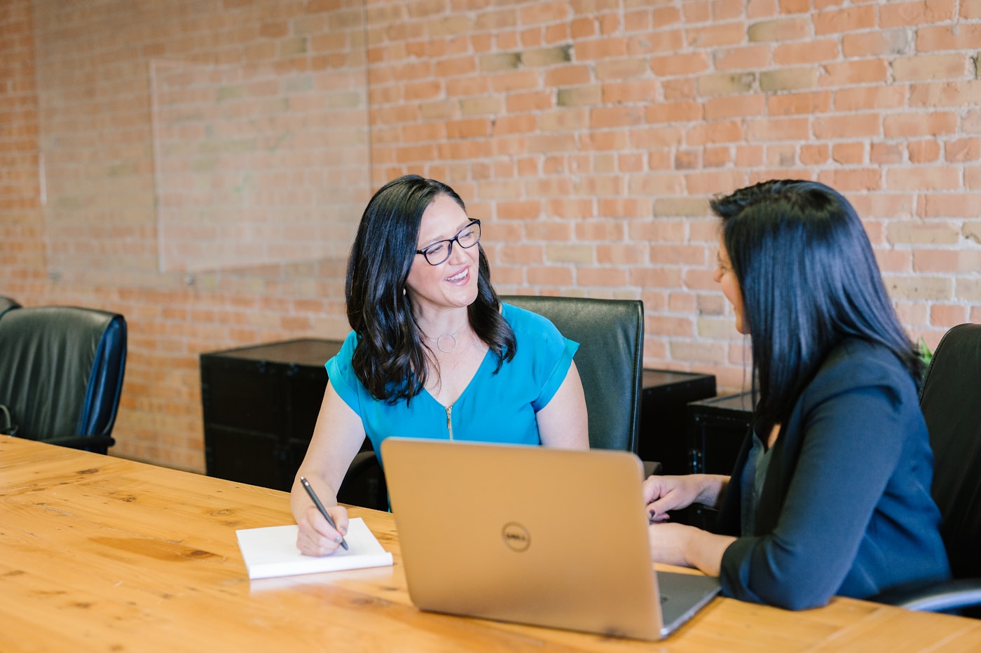 Smiling support specialist at a computer with headset, helping customers with care